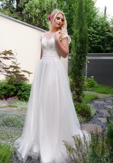 Hochzeitskleid aus Soft-Tüll in Creme, Oberteil mit grober Spitze. Brautkleid mit Tattoo - Effekt und fließendem Rock.
