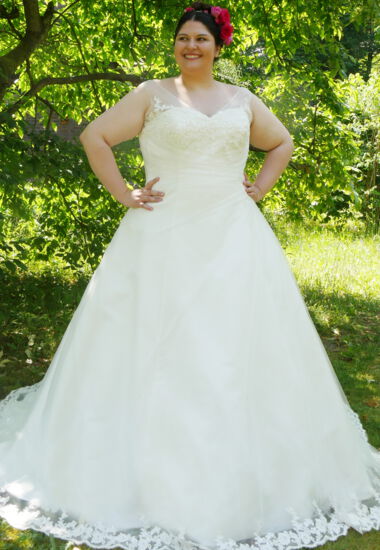 Edle Spitzenverzierungen und Raffungen an dem Oberteil schmeicheln der Figur. Brautkleid in A-Linie in Creme.