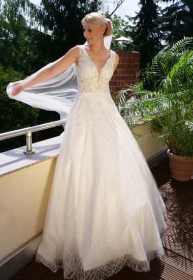 Brautkleid mit semitransparentem Oberteil und verspieltem Rock mit Glitzertüll in A-Linie.