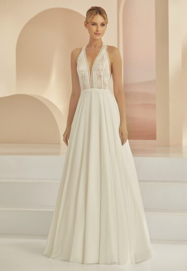 Der Neckholder - Ausschnitt betont die Schulterpartie der Braut besonders schön. Das Hochzeitskleid vereint Vintage und Boho Elemente.